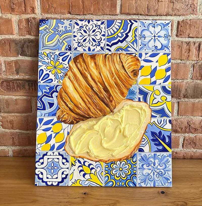 A drawing of a cut croissa on a plate with a tile pattern