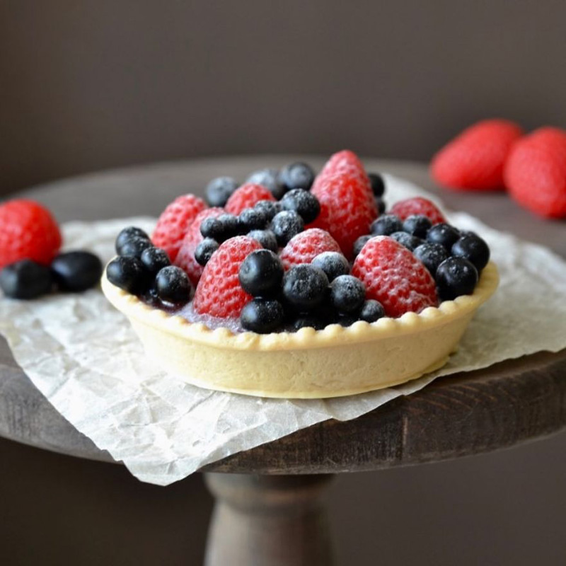 Soap in the form of a tart with toppings of differe types of berries 