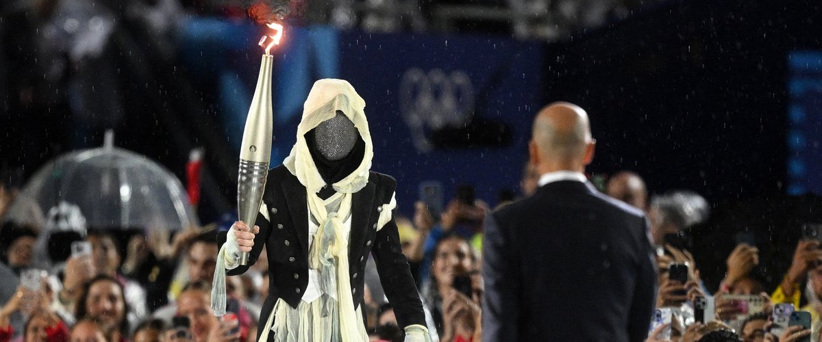 The unknown bearer of the Olympic torch is a famous French parkourer and stuman.