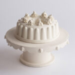 A porcelain statue of a cream cake on a stand