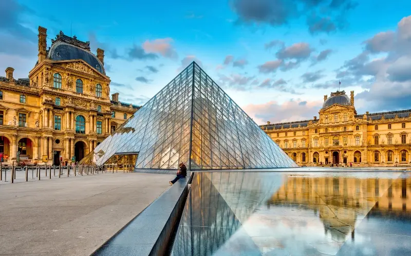 Paris Louvre museum in cloudy sky; Photo source: www.cntraveler.com/activities. Photographer: Unknown