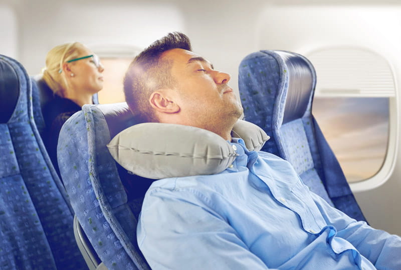 Sleeping with a neck pillow on the plane, photo source: young pioneer tours website, photographer: unknown