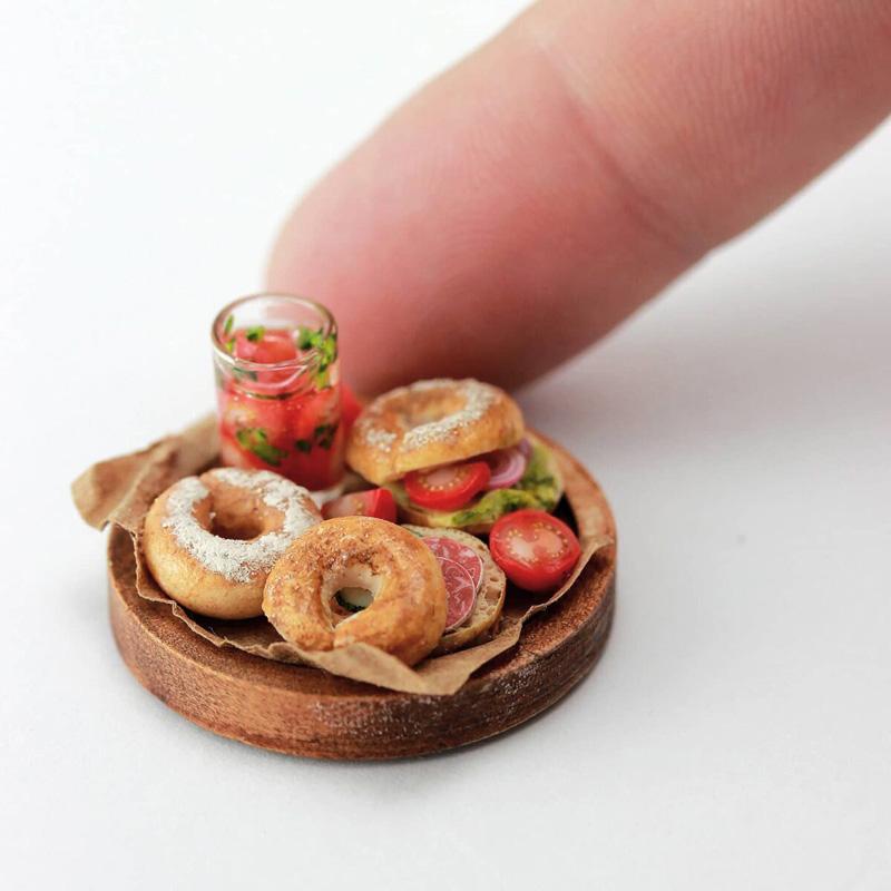 A miniature dish coaining bagel bread and vegetables made by Shai Aaron