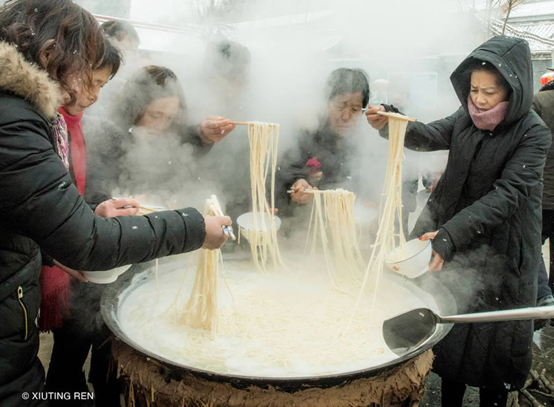 People next to the boiling noodle pot