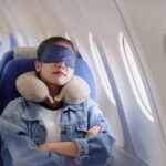 Tourist sleeping with a neck pillow and blindfold in the airplane seat, photo source: NBC news website, photographer: unknown