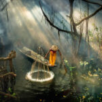 Asian fisherman in the forest river