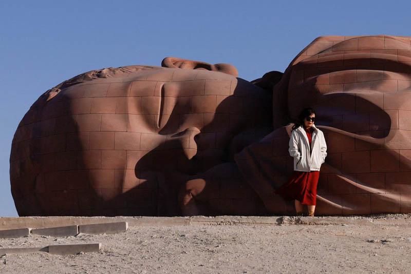 Photo with the Son of Earth statue, in the form of a sleeping baby in the Gobi desert in Gansu Province, China; Photo source: the guardian; Photographer name: Tingshu Wang