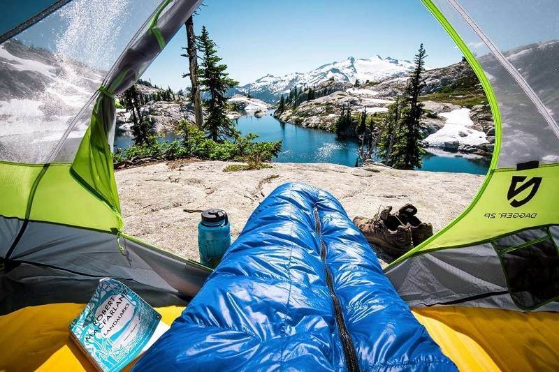 resting with a sleeping bag in a te; Photo source: Washington State Tourism website. Photographer: Unknown