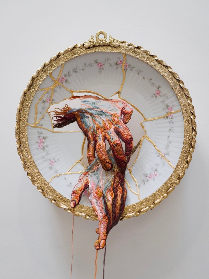 A two-hand design on an embroidered porcelain plate