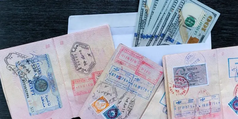 Stamped passport pages and hundred dollar bills; Photo source: blog.poiproperty.com, photographer: unknown