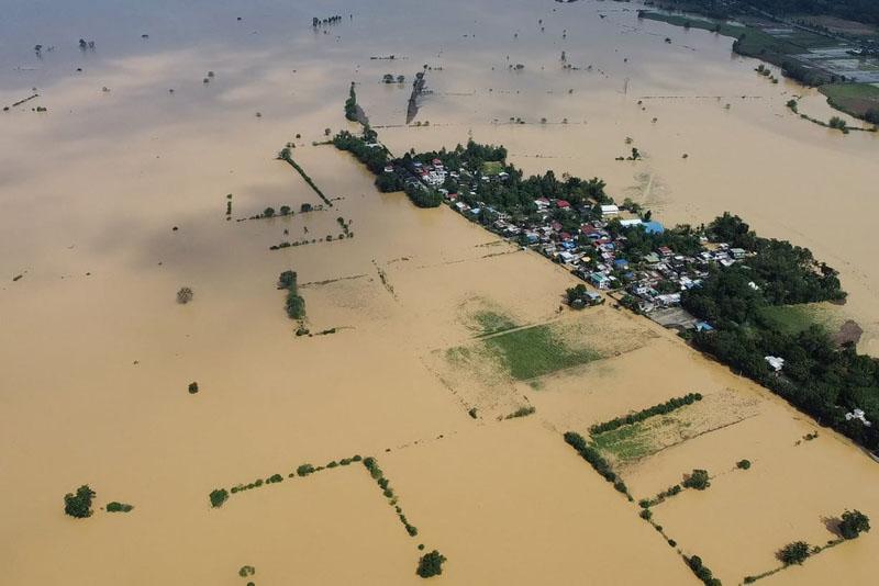 The flooding of a river, a day after the Toraji storm, flooded the fields and houses in the village; Photographer: Villamor Visaya 