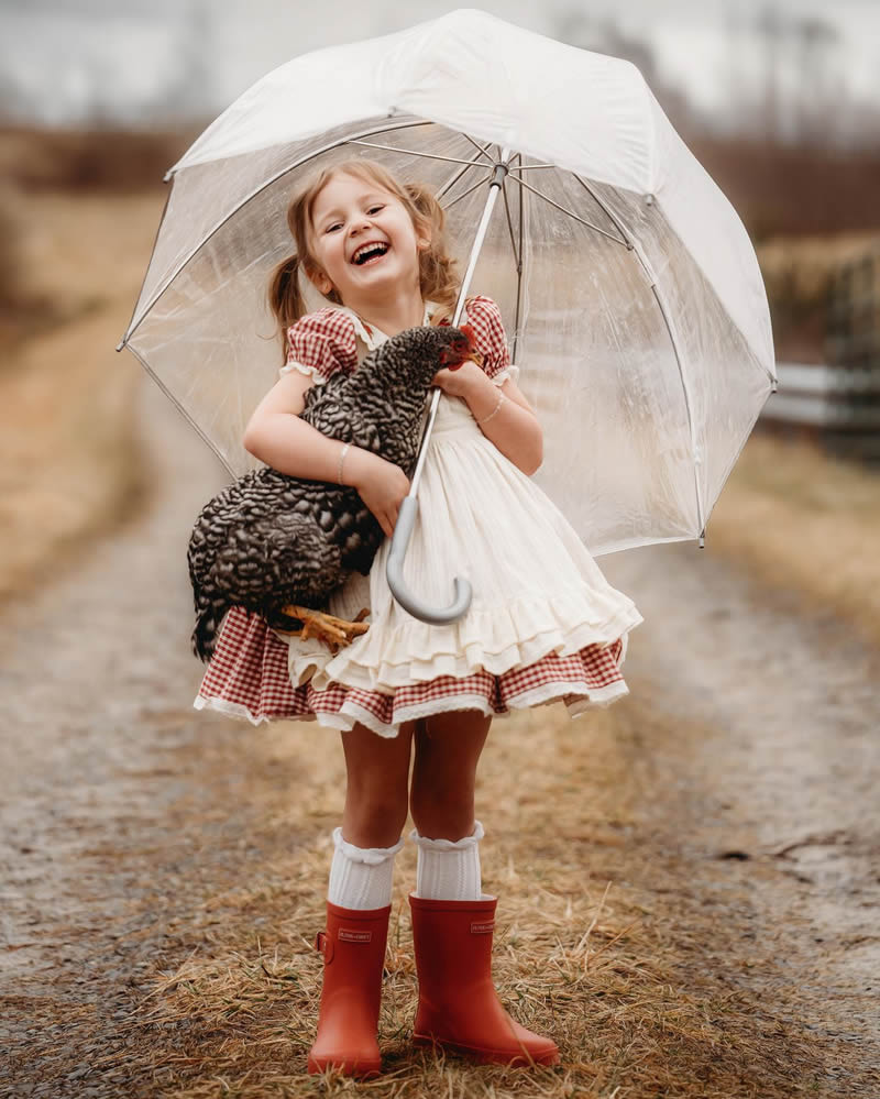A chicken in the arms of a little girl