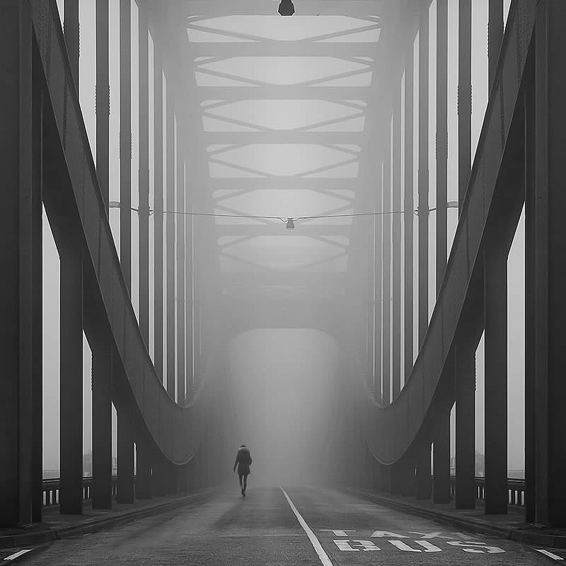 A person crosses a fog-filled bridge in Hamburg