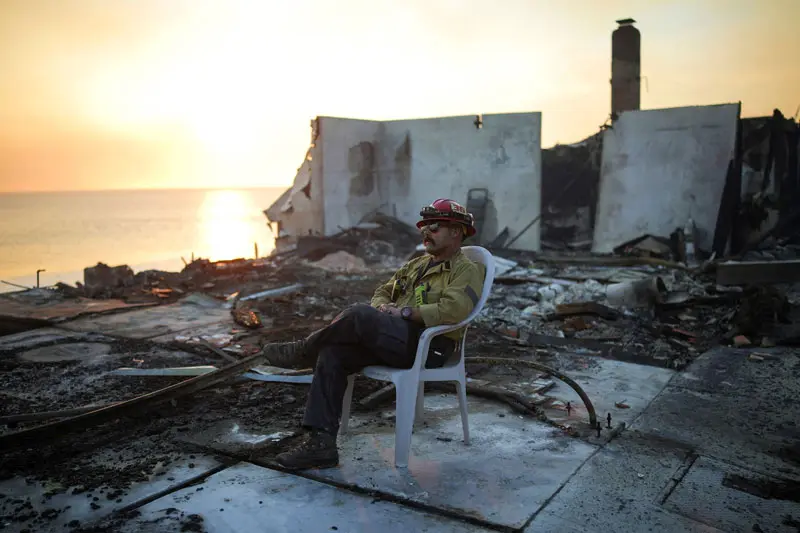 Firefighters in the ruins of the Los Angeles fire; Photo source: Reuters; Photographer: Daniel Cole