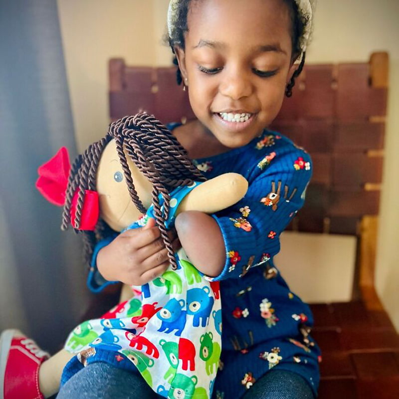 A black girl and a doll like herself
