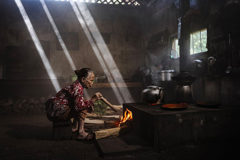 Asian old woman next to the stove; Photographer: Partha Pratim Roy from India