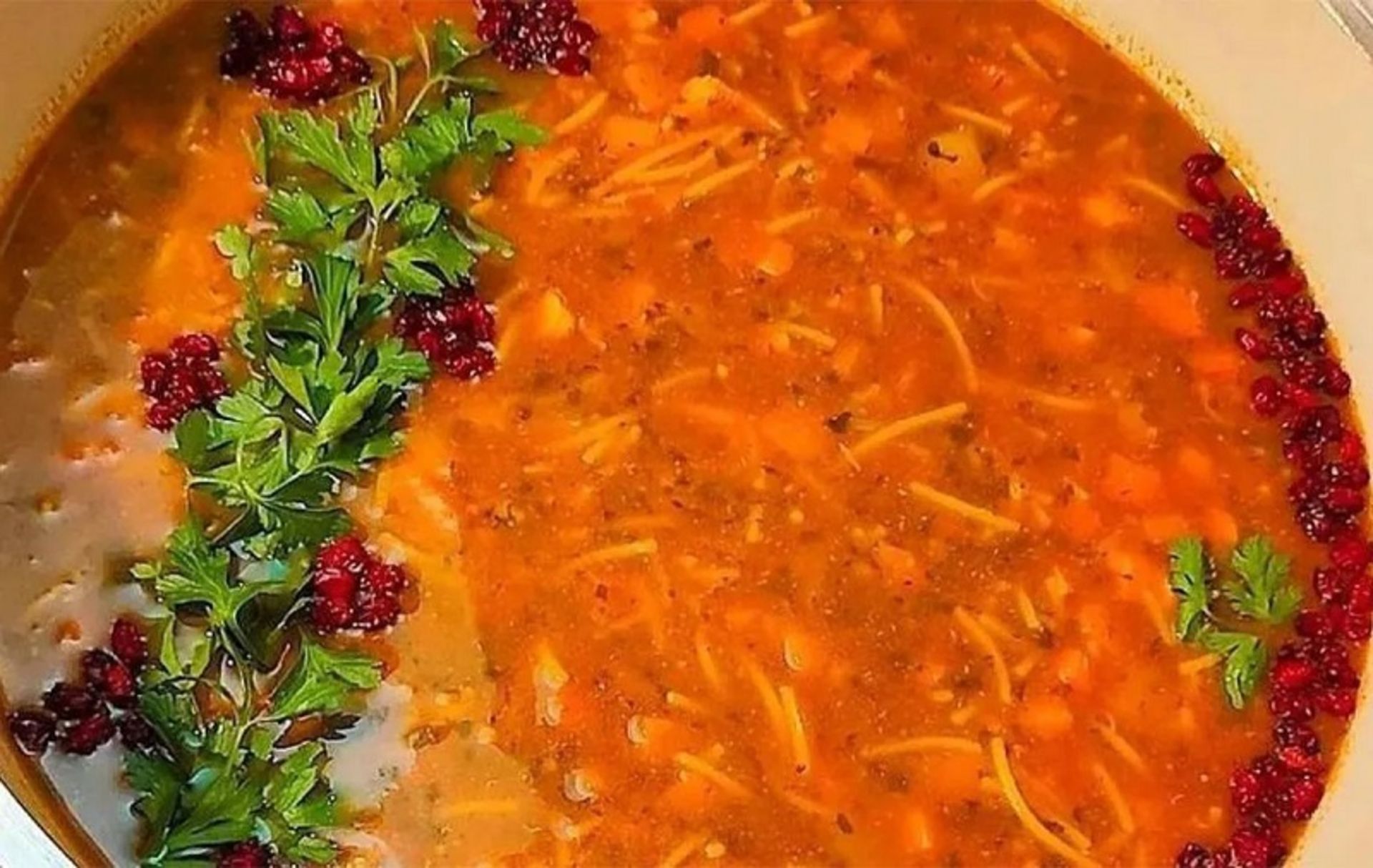Vermicelli soup with parsley and barberry decoration