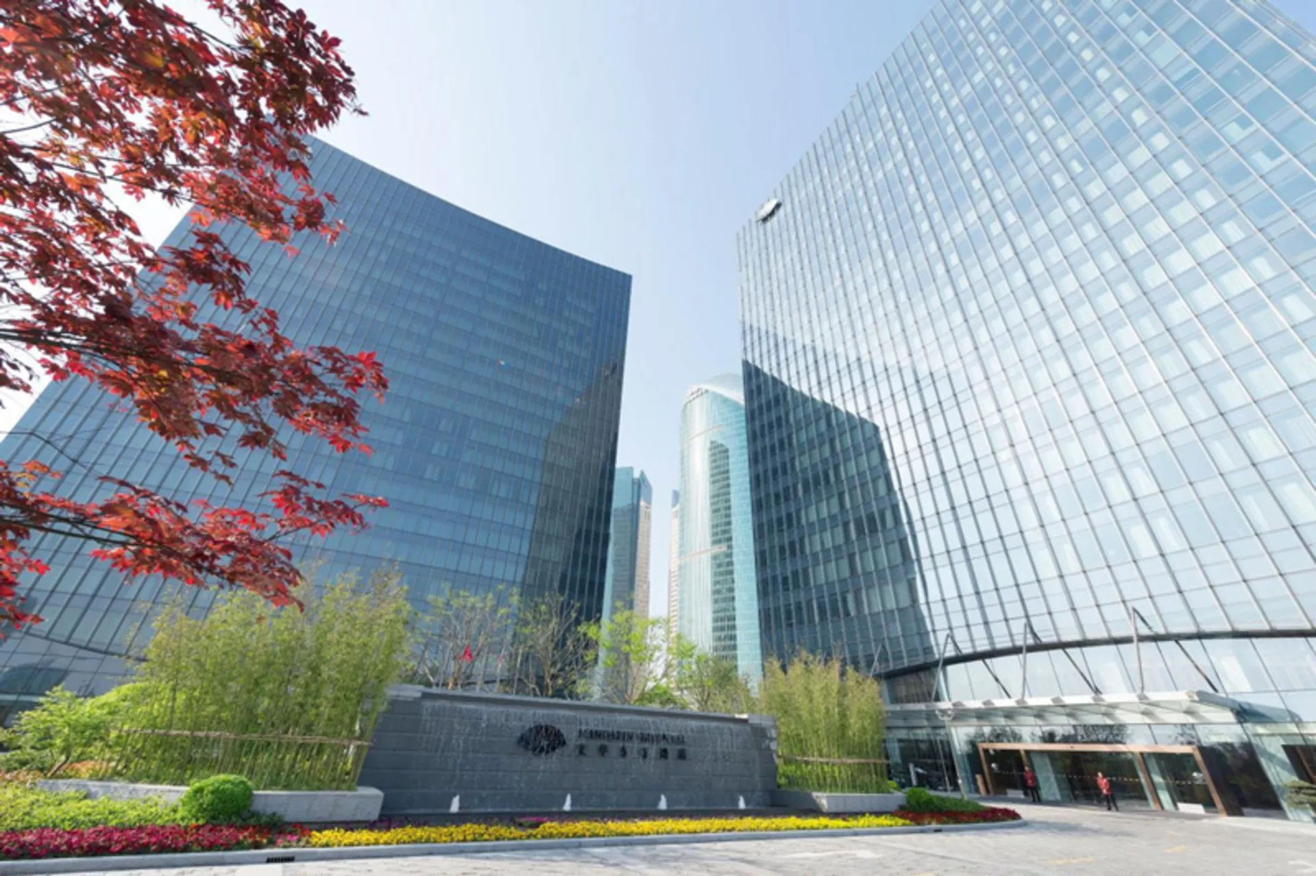 Building Mandarin Orieal Hotel Shanghai next to trees blossom