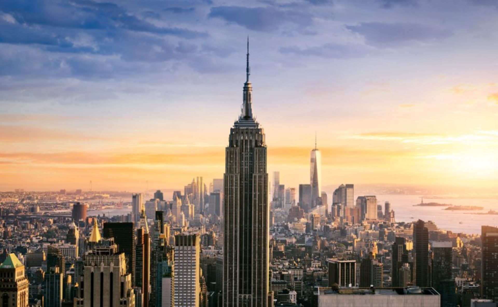 Empire State Building among Urban Buildings in Sunset