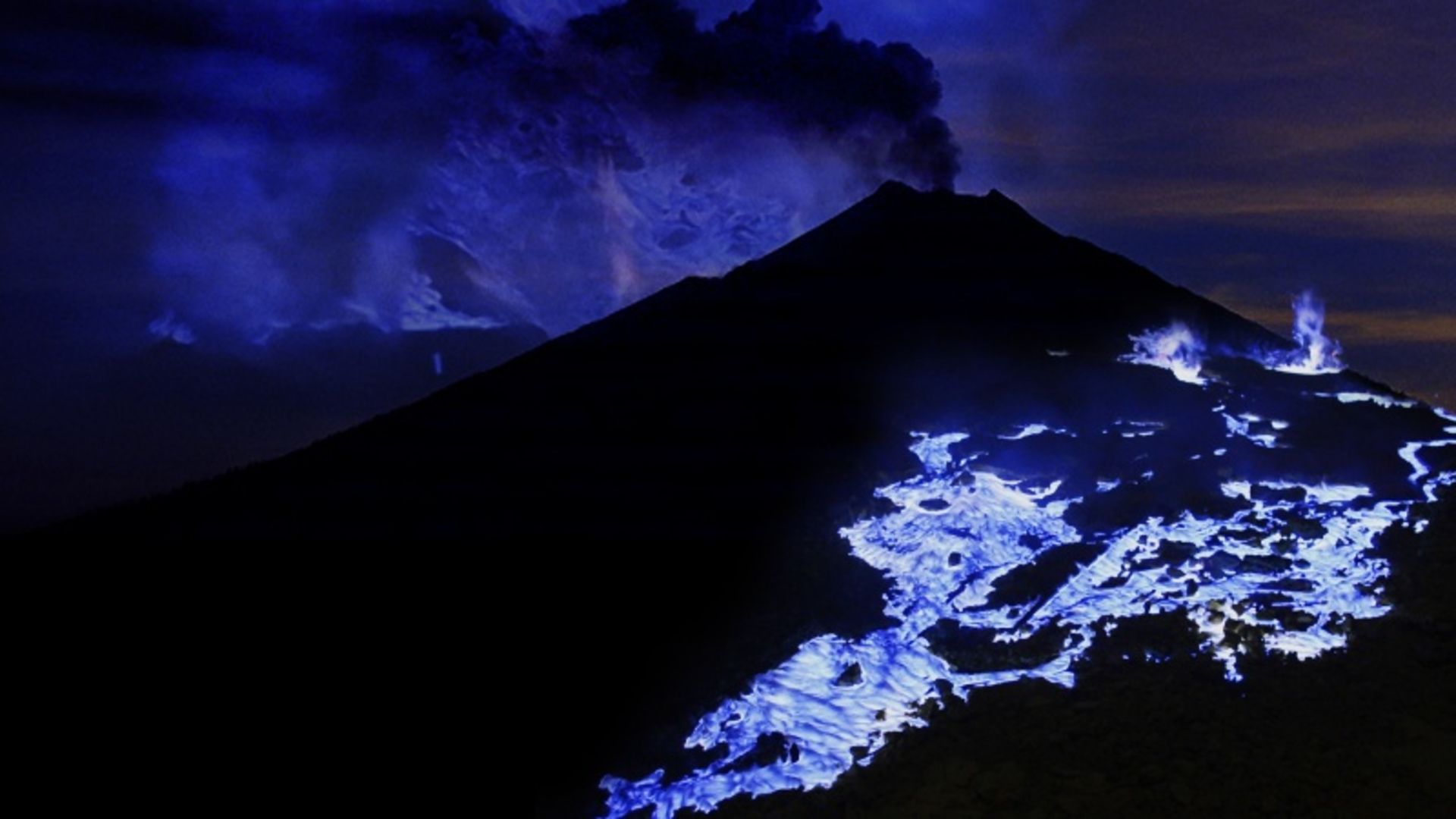 Blue flames of Kava Ajan volcano at night