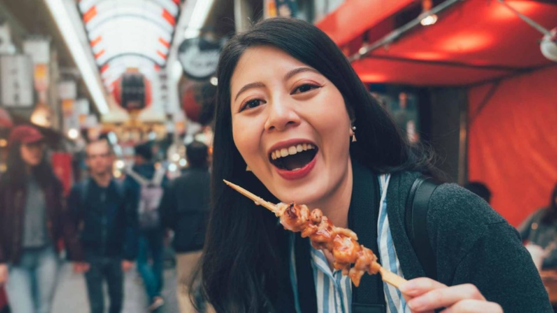 Tourist female with food grill on Japan Street