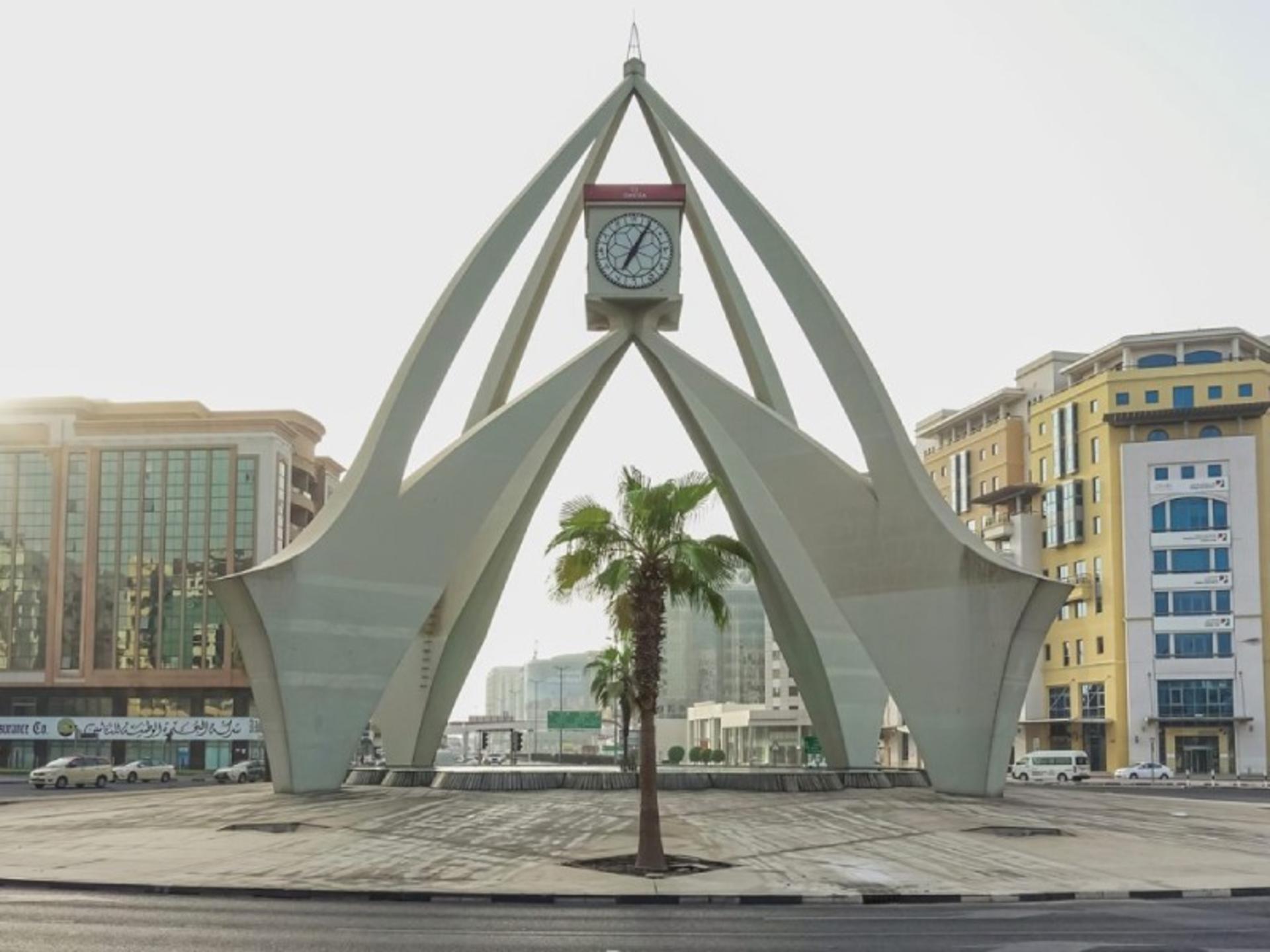 Dira Clock Tower next to modern Dubai buildings