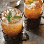 Two glasses of ash syrup with ice and mint leaves