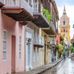 Colorful Street in Carthaneh, Colombia with historic buildings and church tower in the background