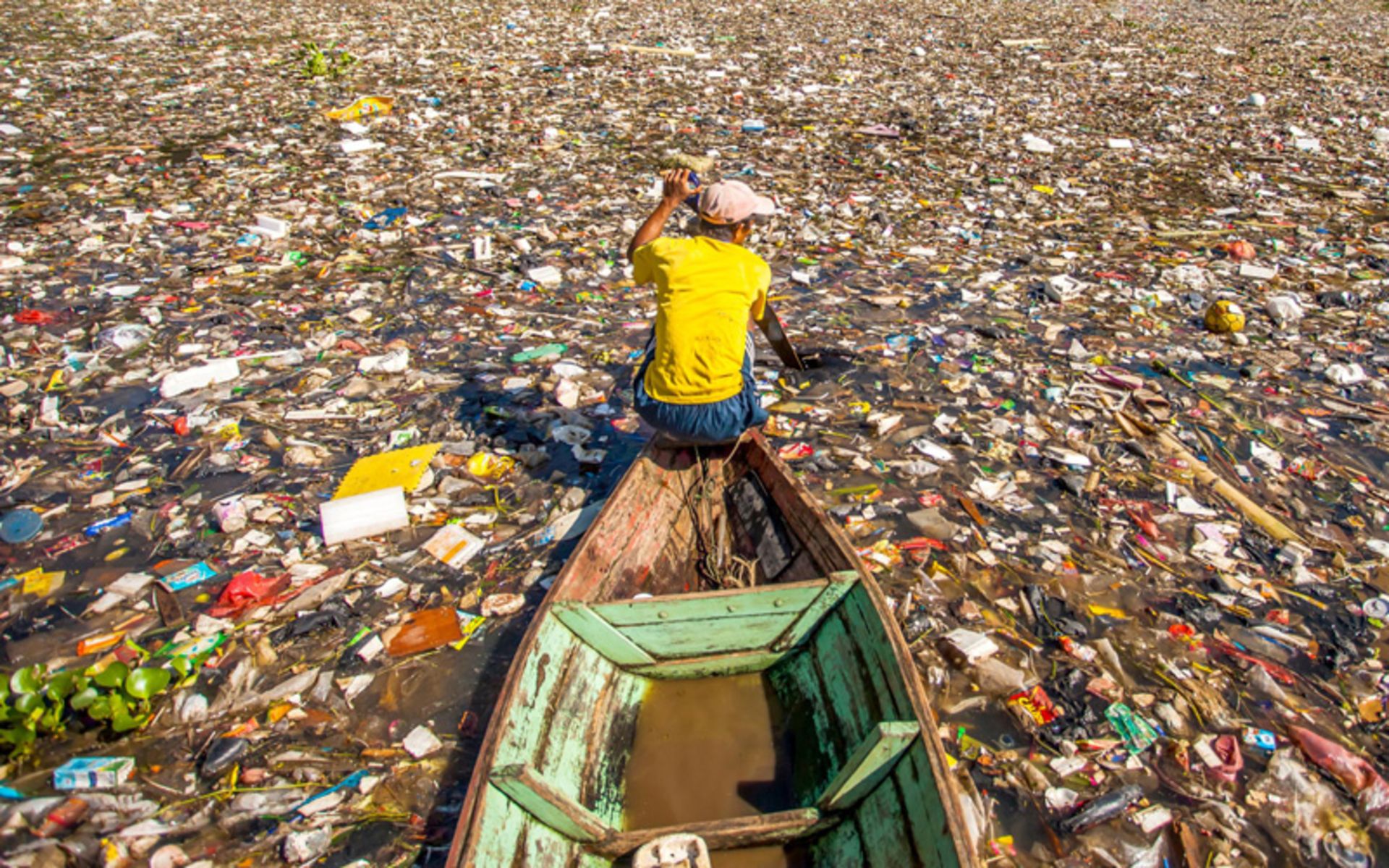 Boat crossing through plastic waste