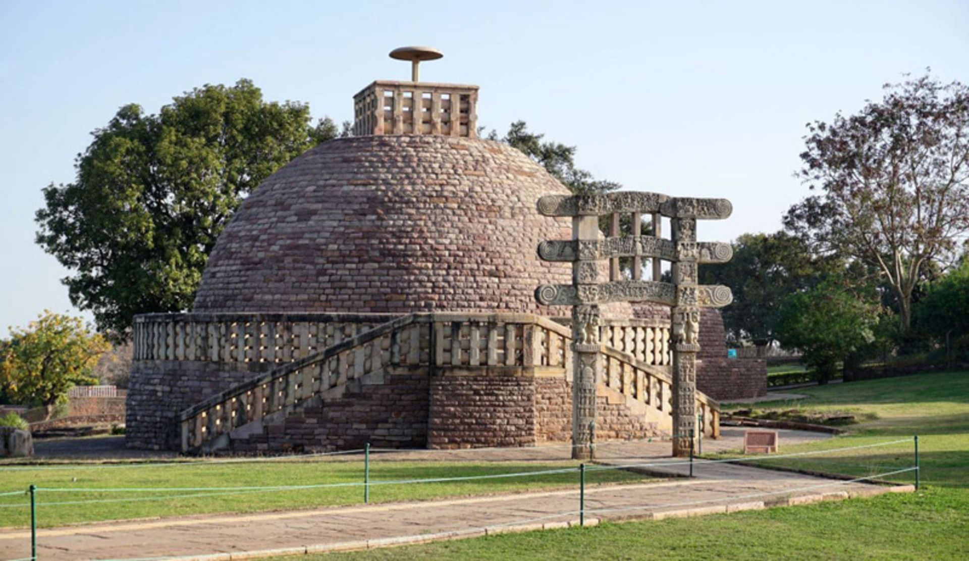 A large stone stupa with a hemisphere in Sanchi, India