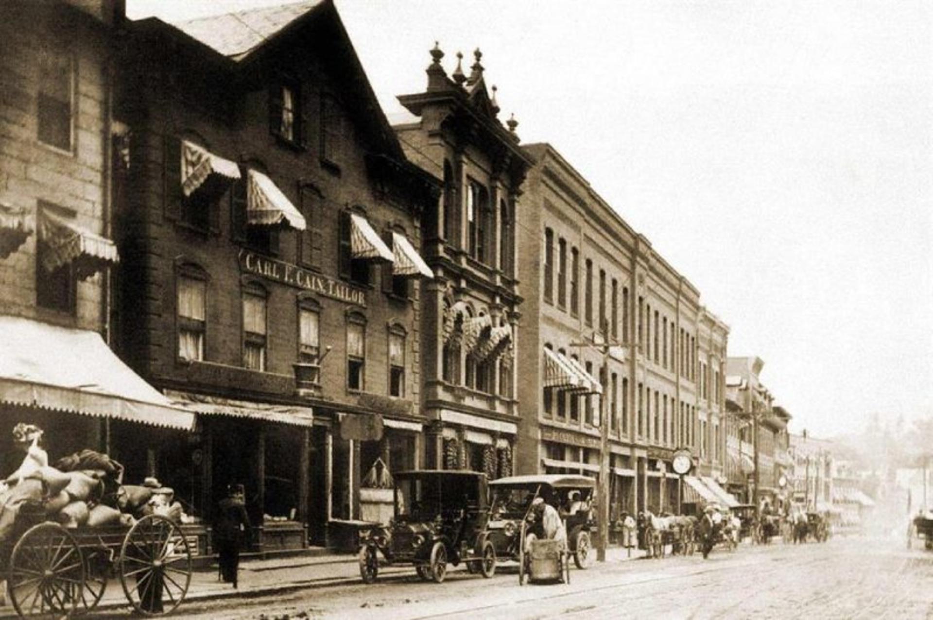An old image of buildings and vehicles on the main street of Braburo 