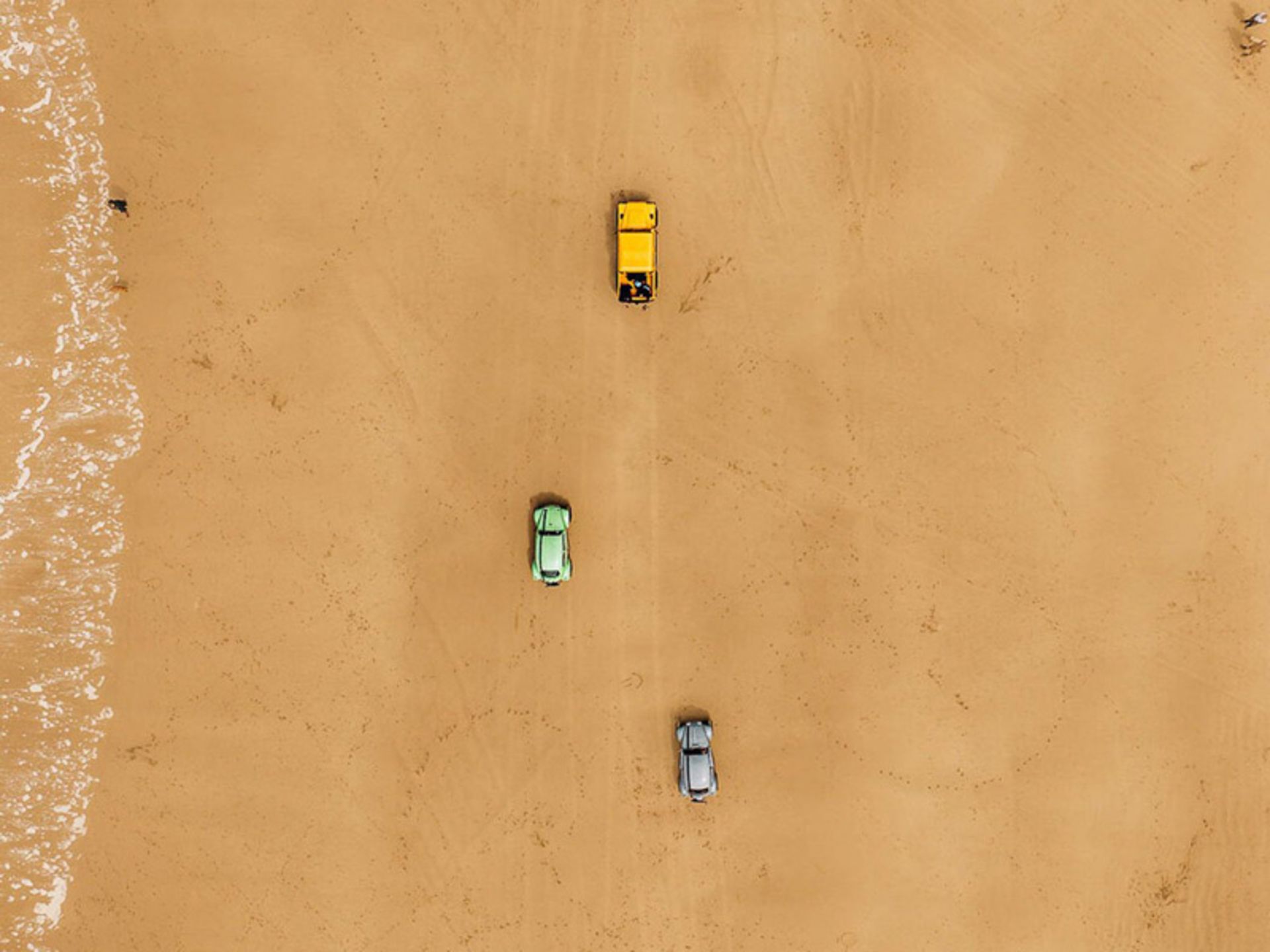 Aerial photo of differe cars on the beach company
