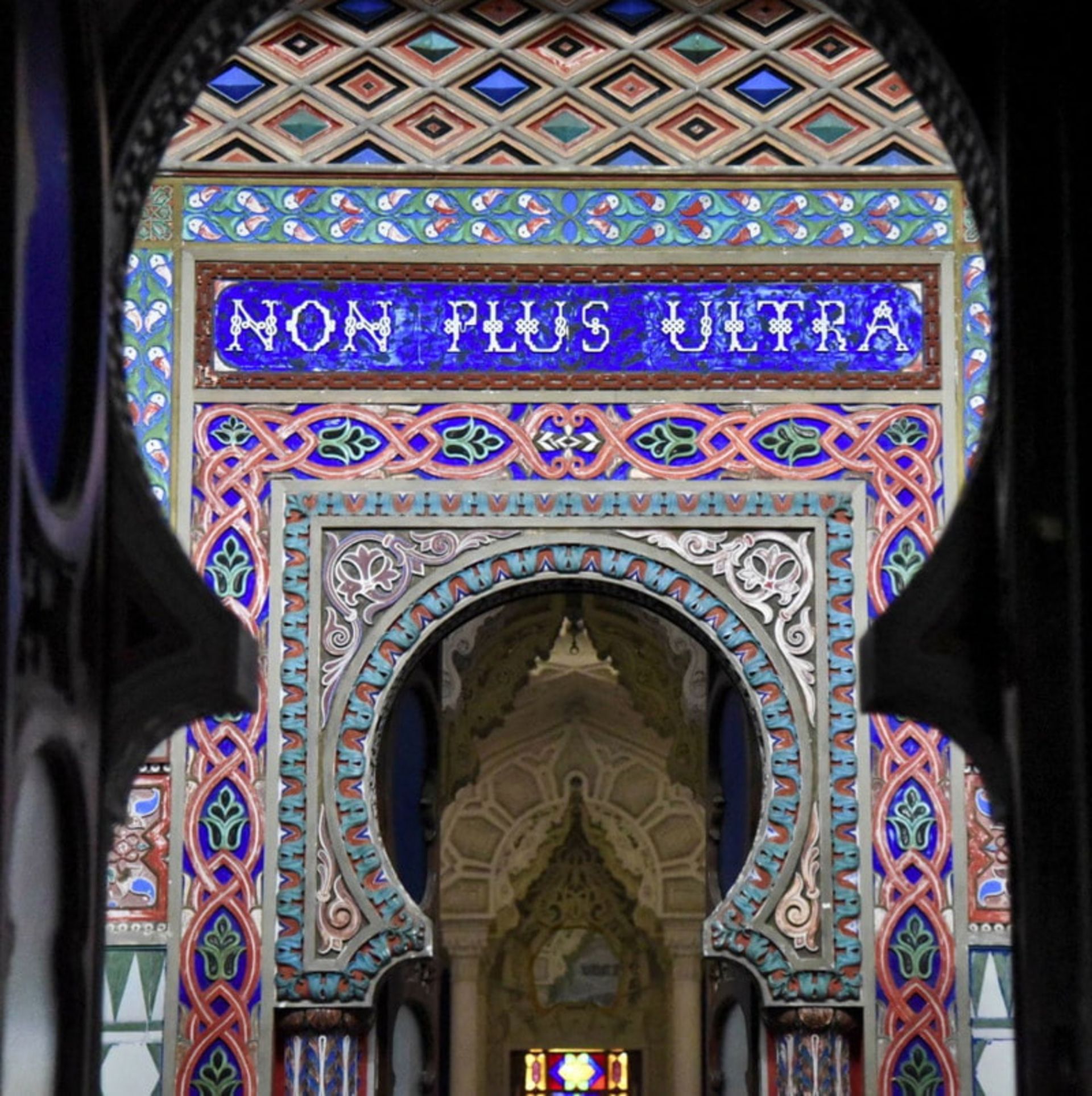 Engraving a Latin slogan on the tile wall and the colorful castle