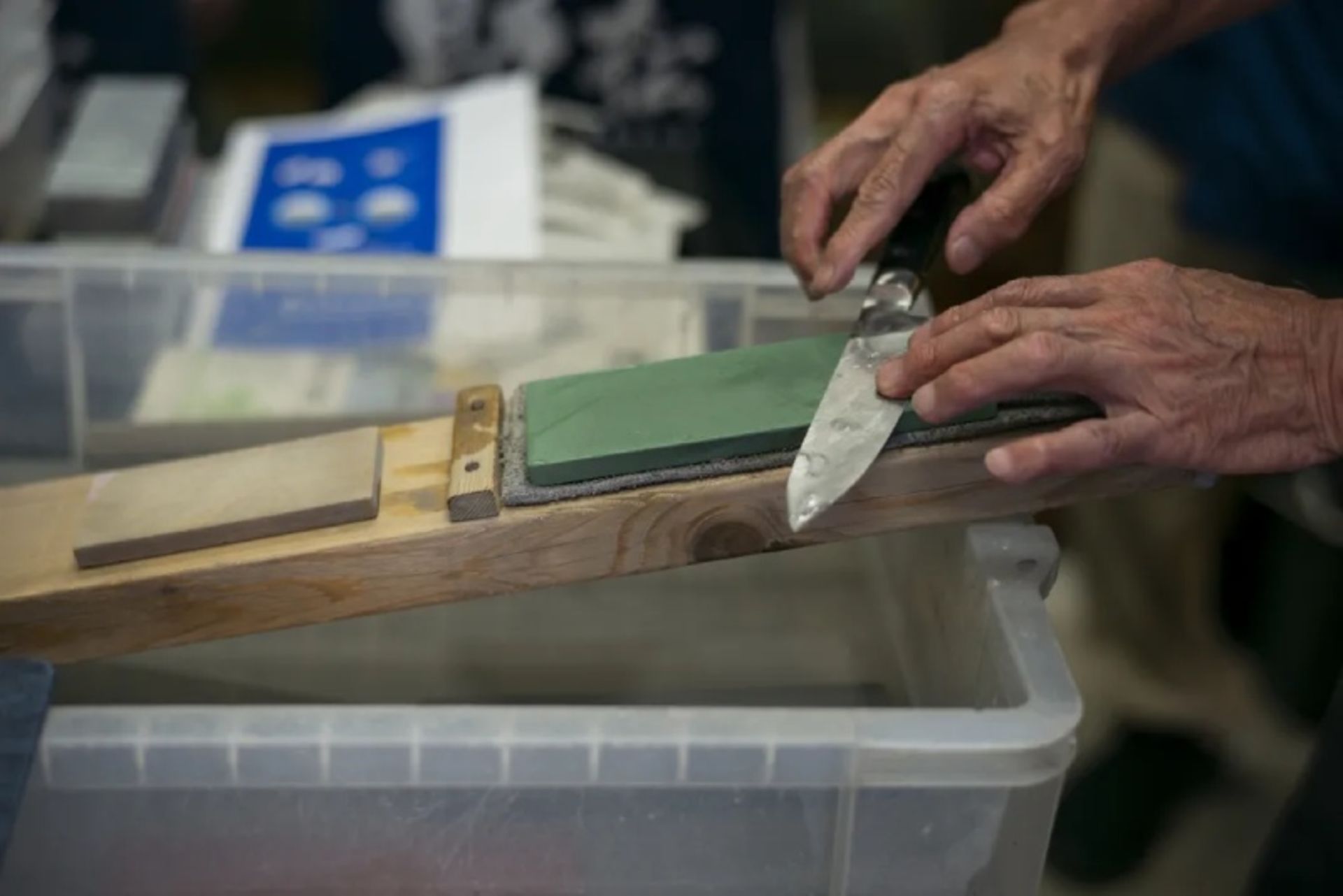 A person sharpening a sakai knife