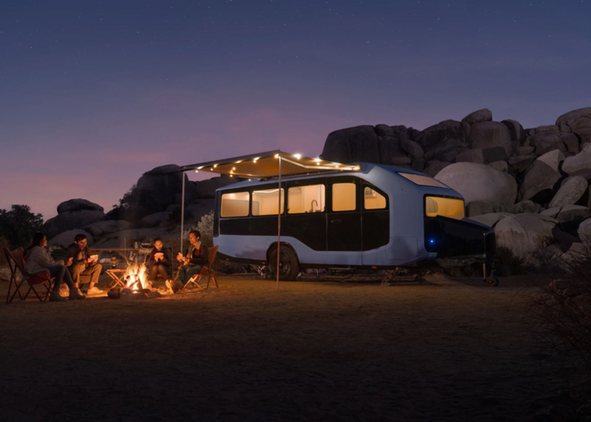 Tourists camping with Pebble Flow Caravan at night