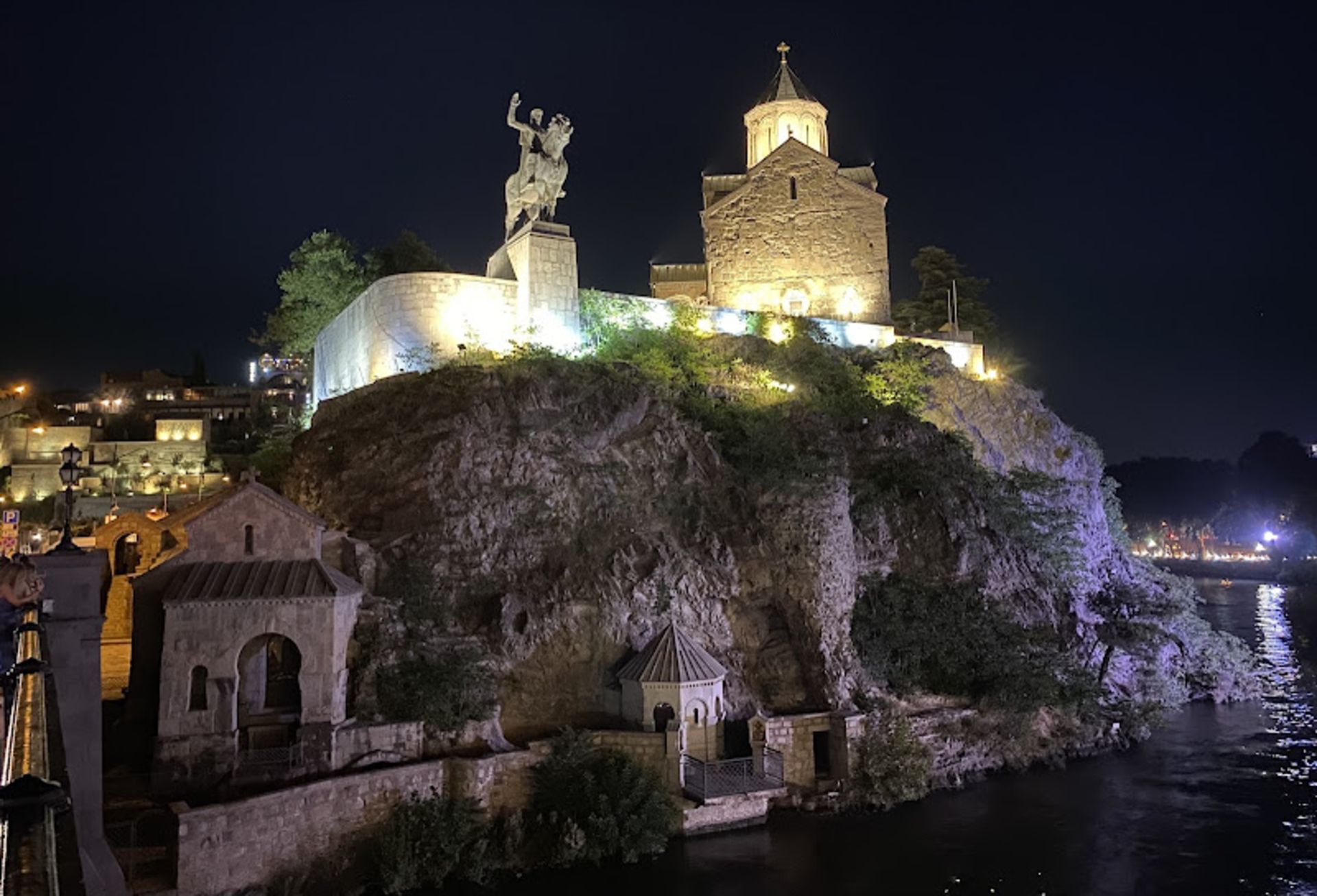 Statue of a man riding a horse on a rock in Batumi