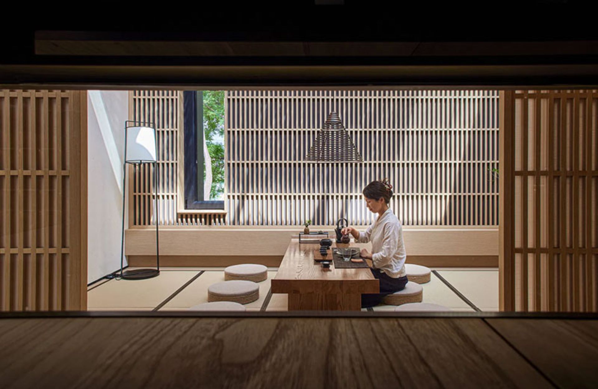 The tea table in the Blue Lake Teahouse, with a wooden lattice wall and a long window
