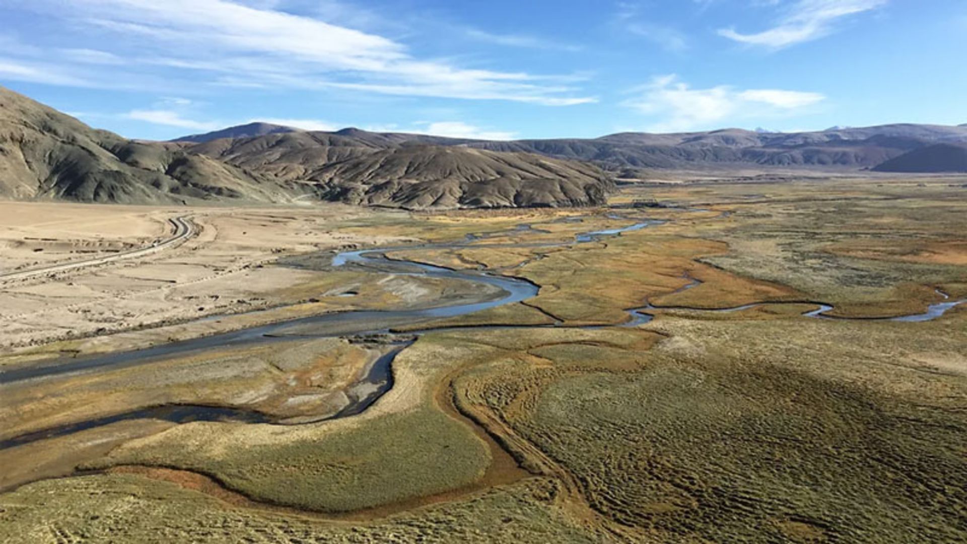 Aerial view of a wide valley with a winding river around Hanle