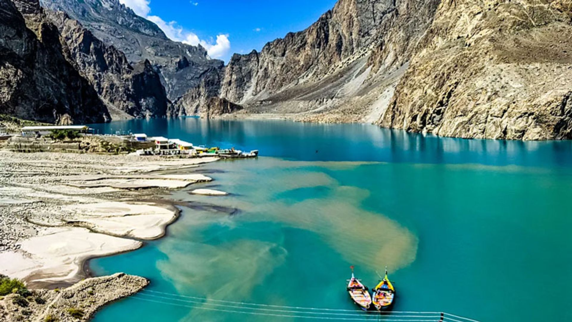 Colorful boats in the turquoise waters of Attabad Lake and the surrounding mouains