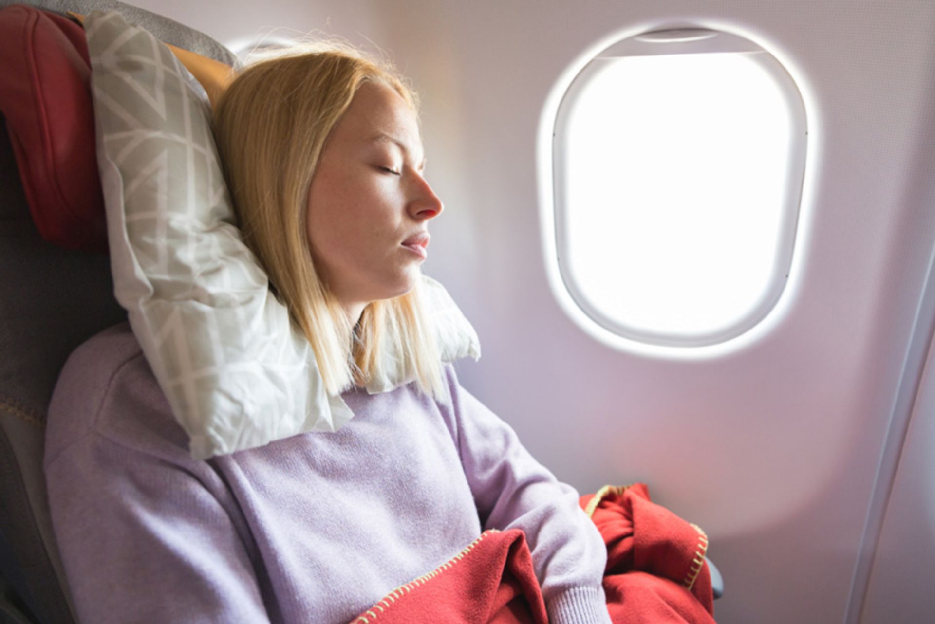 Sleeping passengers with comfort equipme on the plane