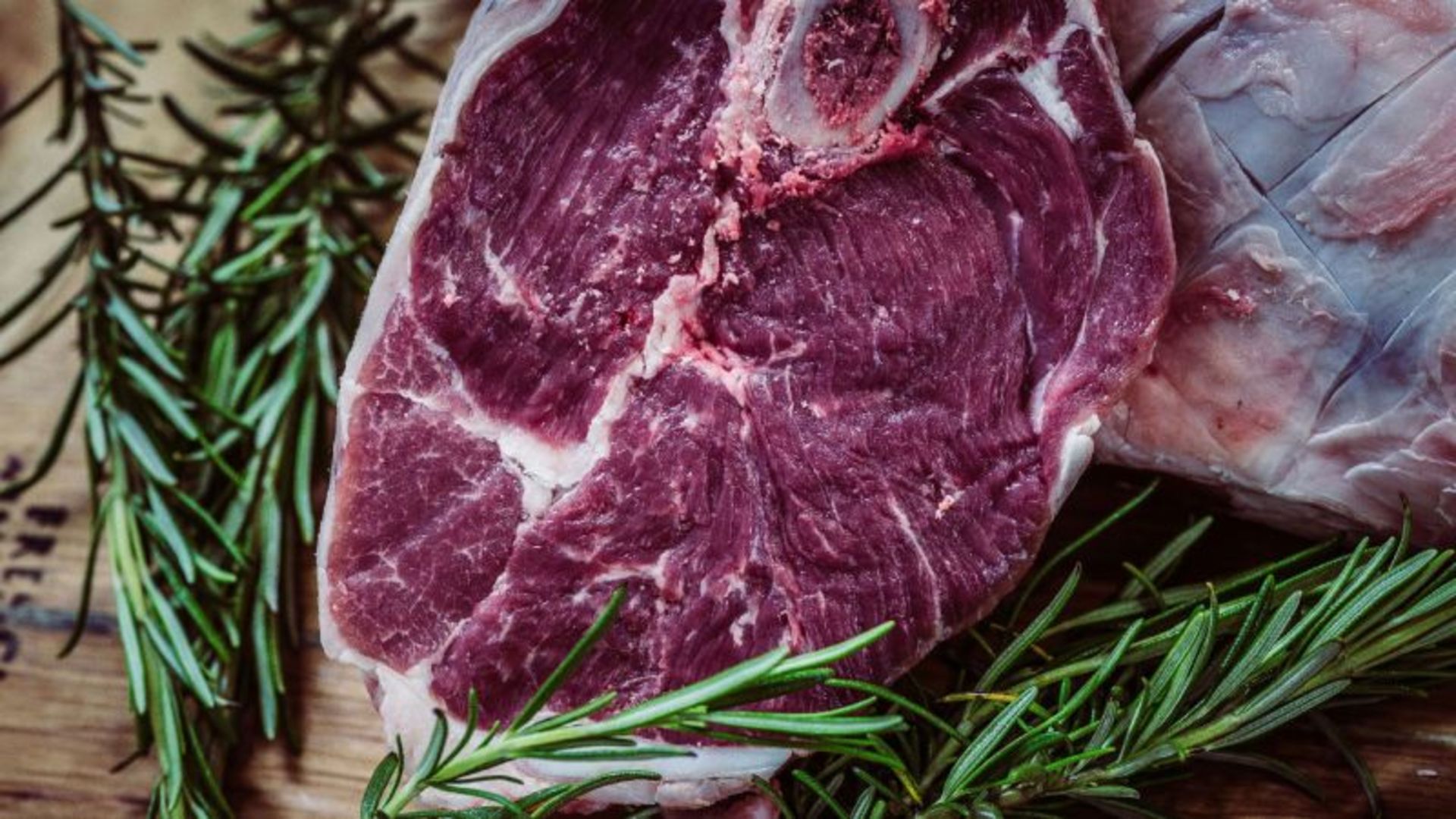 A slice of raw meat with rosemary