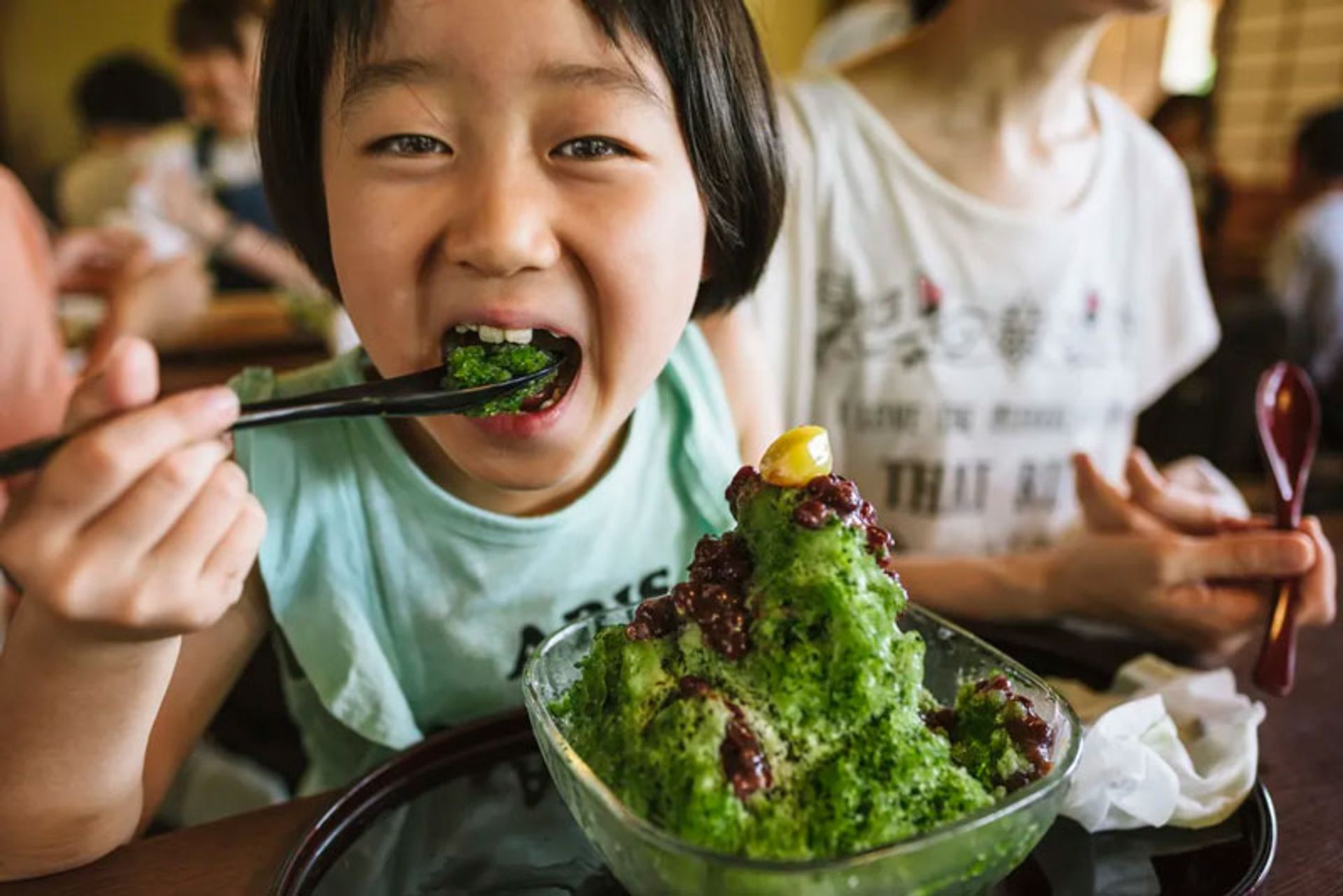 A child eating Japanese green tea flavored kakigori dessert