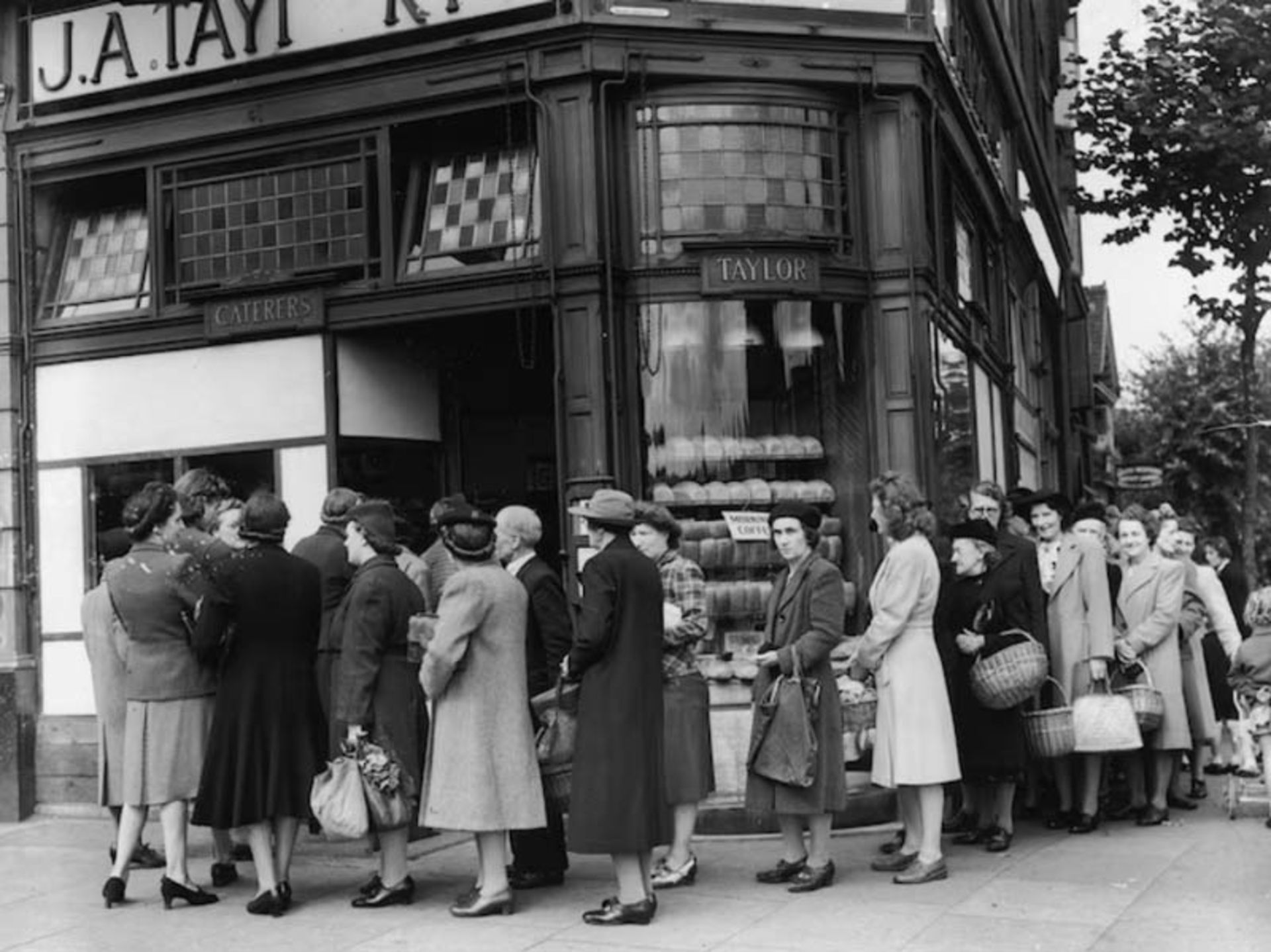 A long line of people in fro of the bakery to receive bread quota