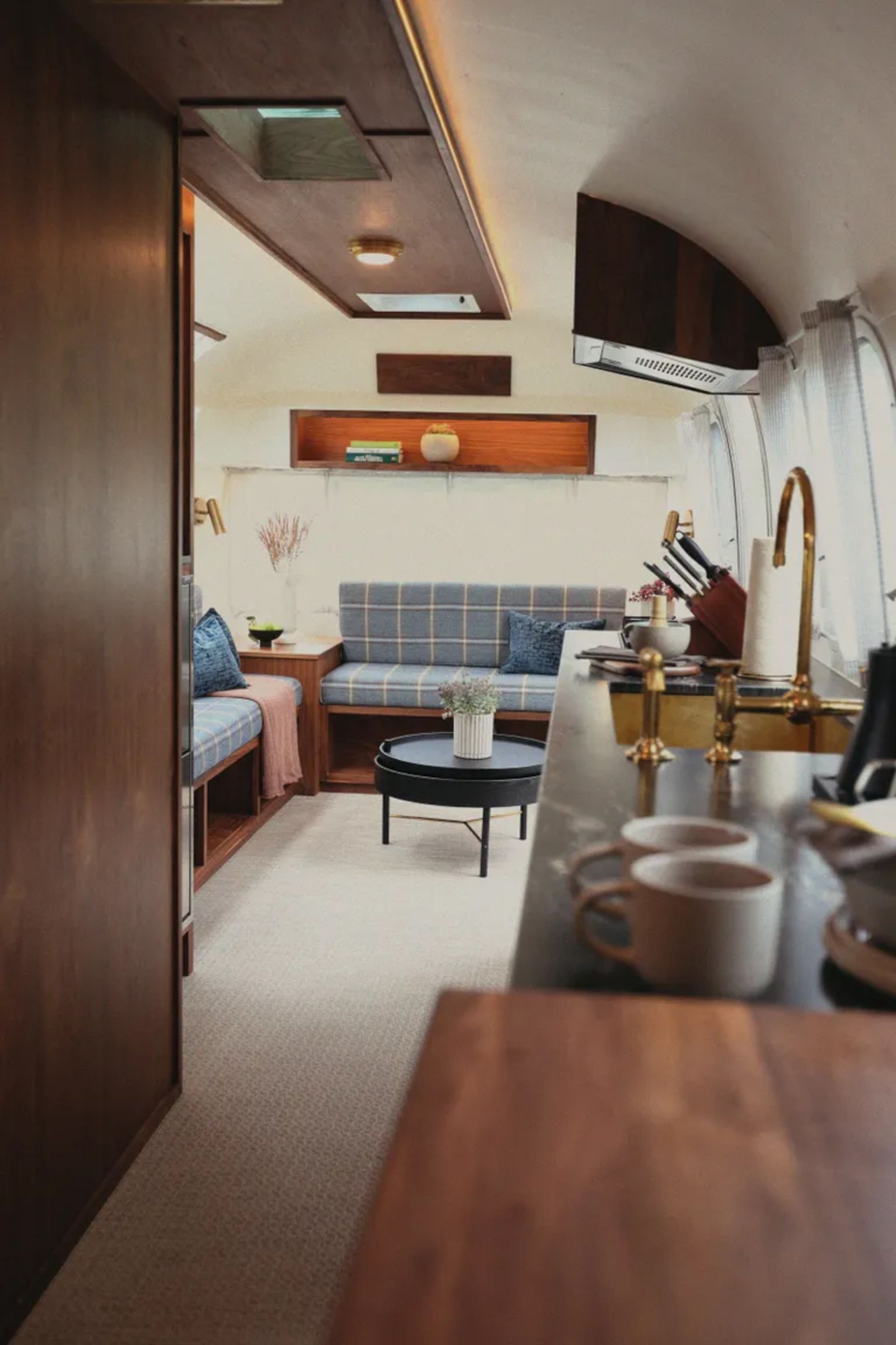 Modern and luxurious ierior design of airstream caravan with wooden cabinets and brass faucets