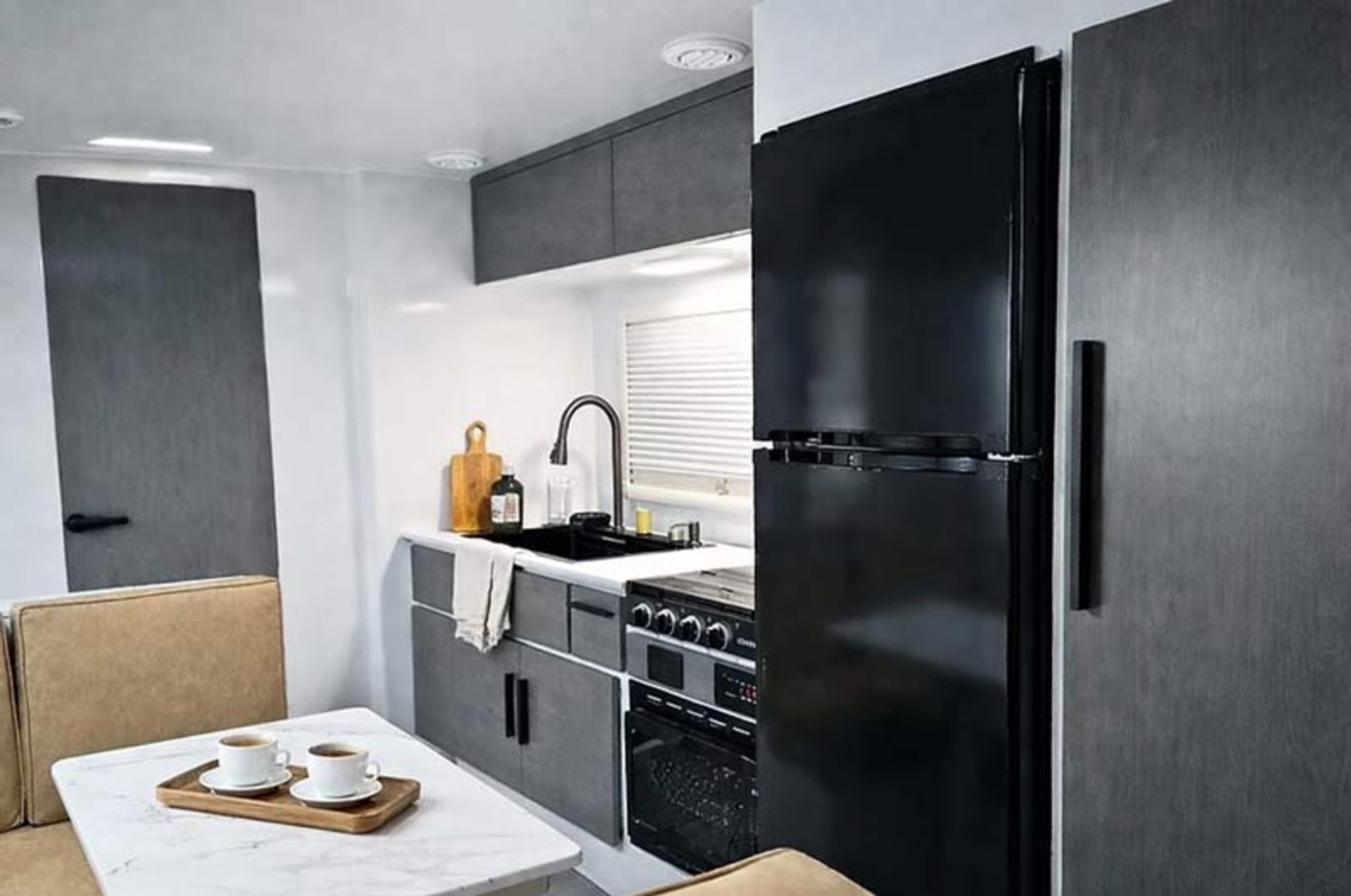 Modern and minimal ierior design of a luxury room with gray cabinets and a large black refrigerator