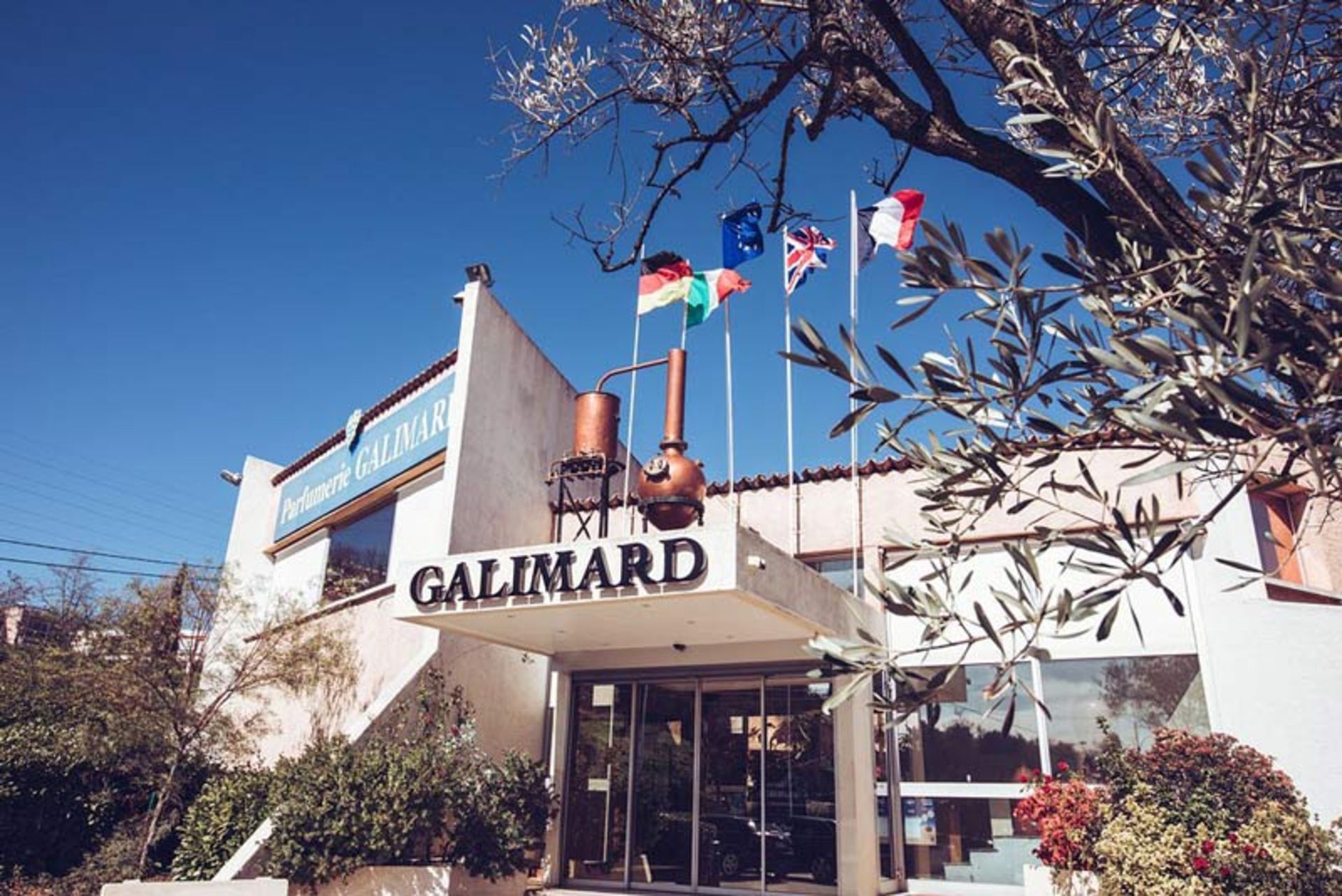 Erance view of Gallimard perfumery building in Grasse, France with raised flags