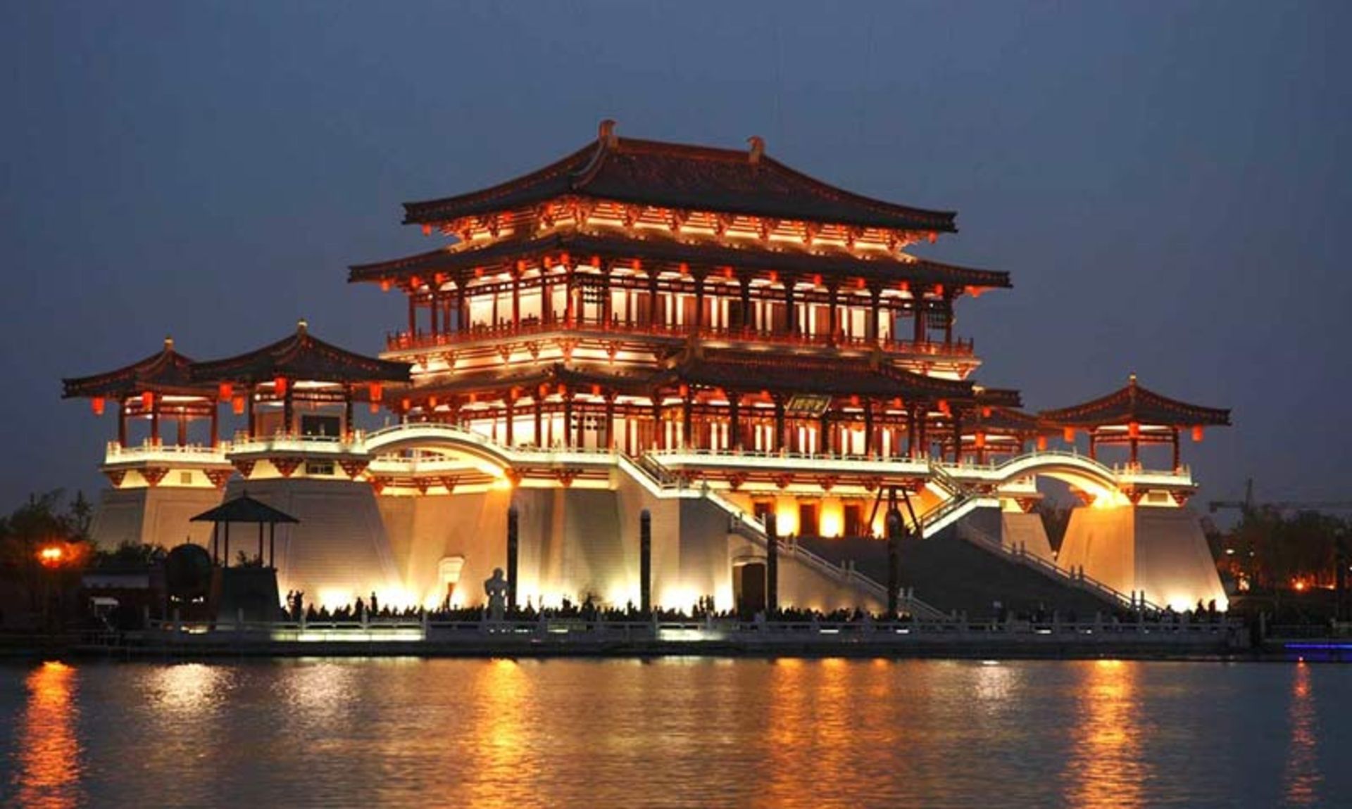A multi-storey building with orange lighting at night
